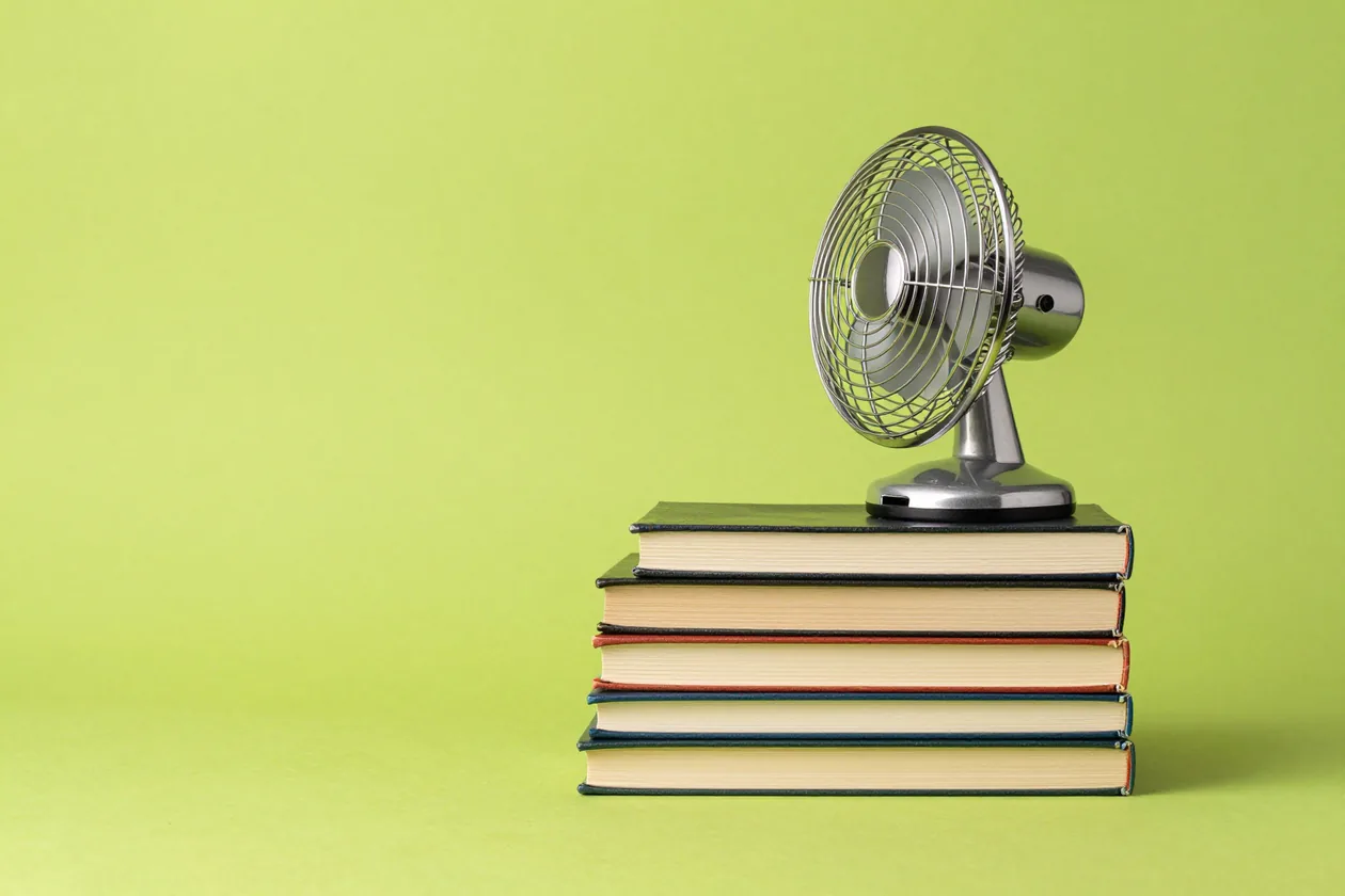 Una pila de libros con un ventilador que levanta las páginas
