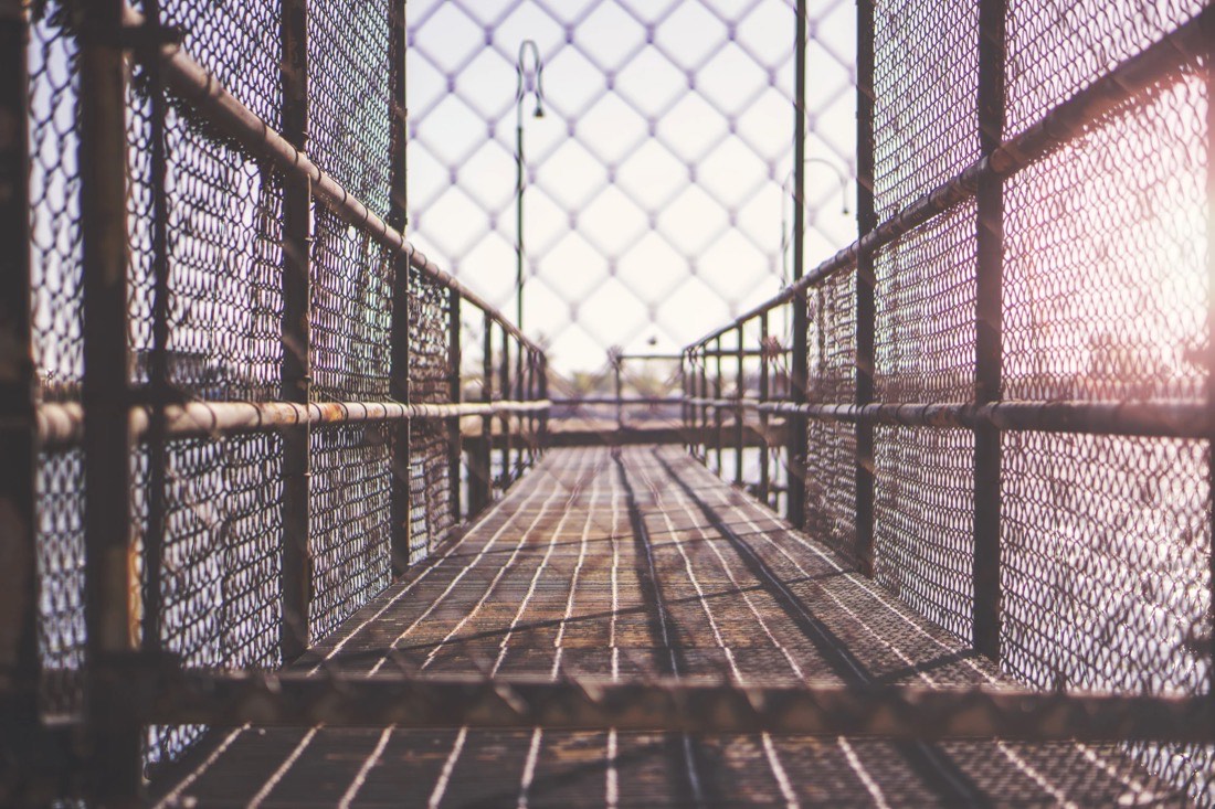 Walkway closed off by metal fencing, a metaphor for control over a platform
